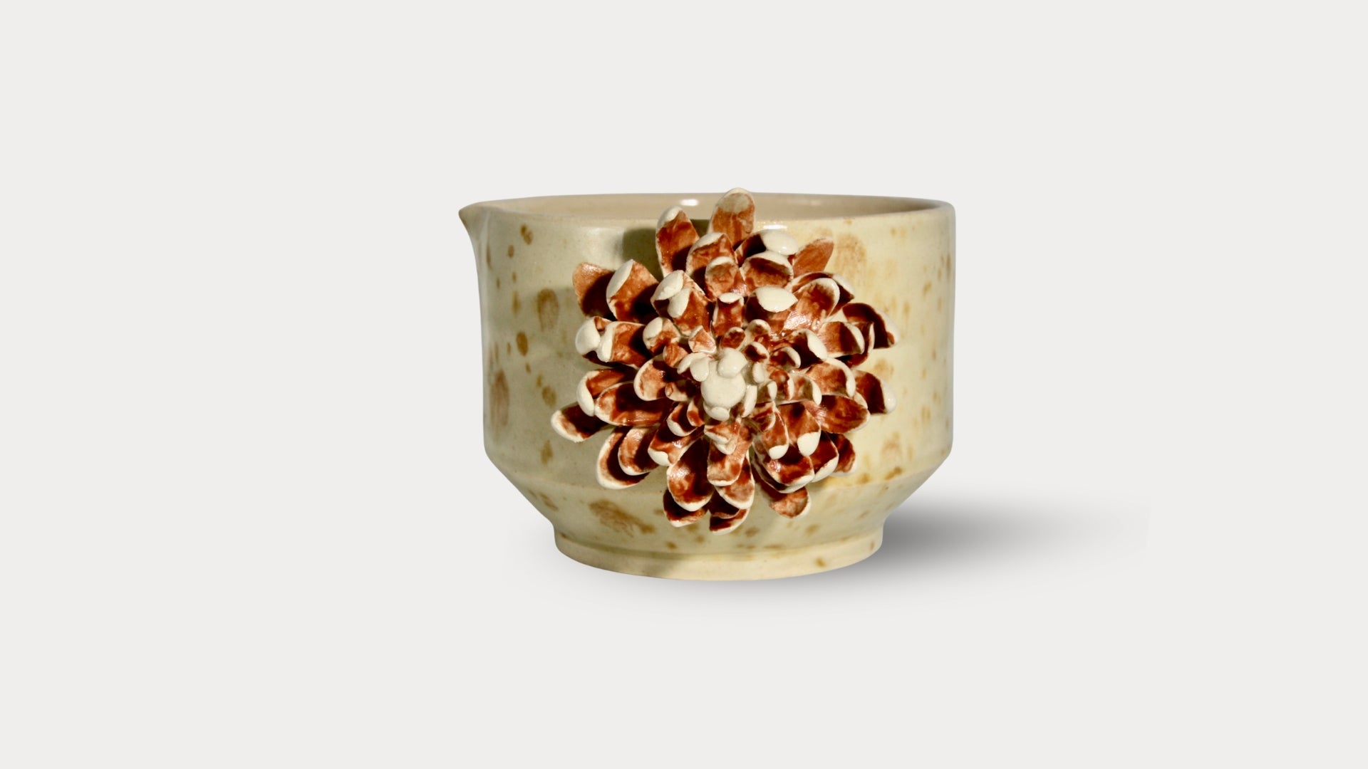 Ceramic cup with floral design on a light gray background